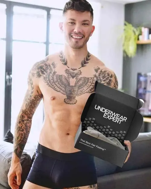 An Underwear Expert community member beside a window holding his box